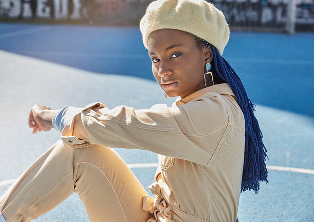 young Afro-woman sitting on a sports-ground