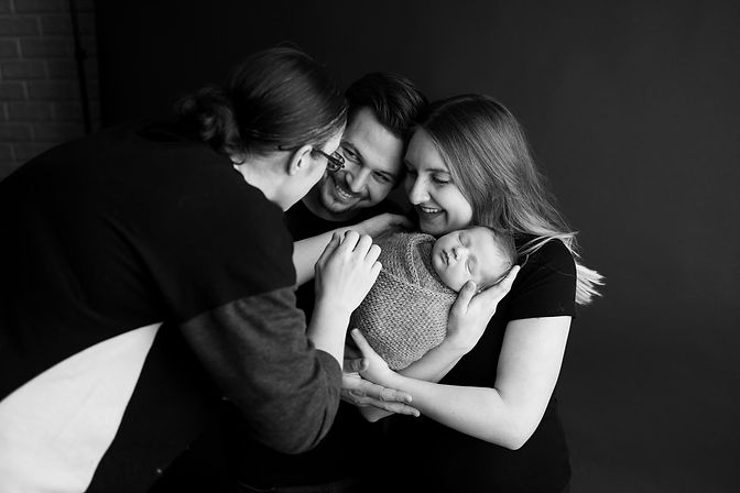 Photographer Ashley Szokola posing a family with a newborn in Fenton, Michigan