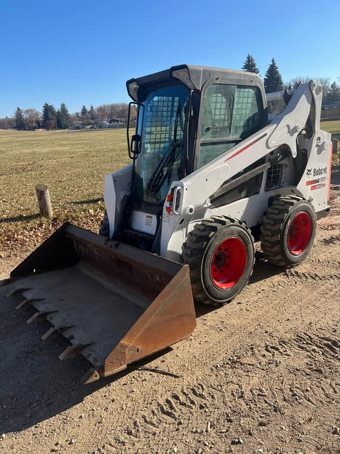 White Bobcat skid-steer loader with bucket