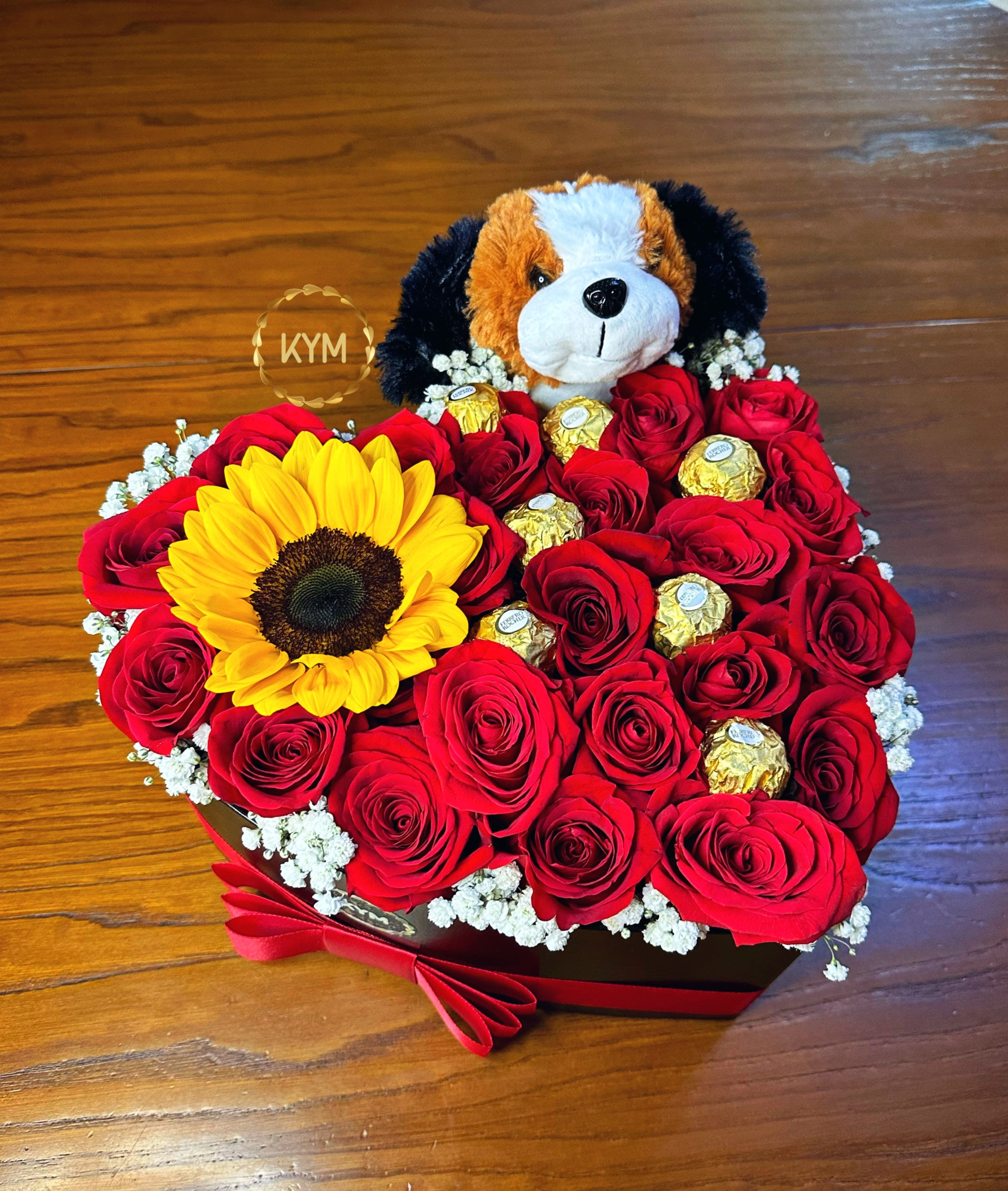 Arreglo de rosas, bombones, girasol y peluche