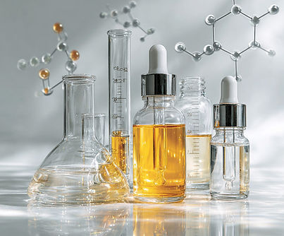 Minimalist scientific flat-lay with glass beakers and droppers representing SKNtelligence’s formulation philosophy.