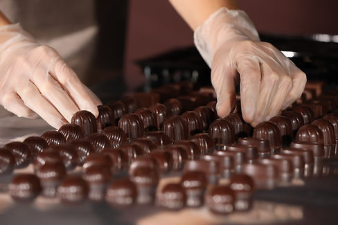 Woman with delicious candies at production line, closeup.jpg
