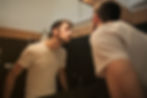 Chico mirando su barba en un espejo pensando en la opción de hacerse micropigmentación de barba