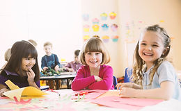 Smiling girls sitting at table in elemen