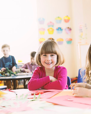 Smiling girls sitting at table in elemen