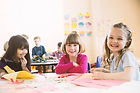 Smiling girls sitting at table in elemen