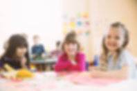 Smiling girls sitting at table in elemen