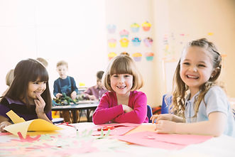 Smiling girls sitting at table in elemen