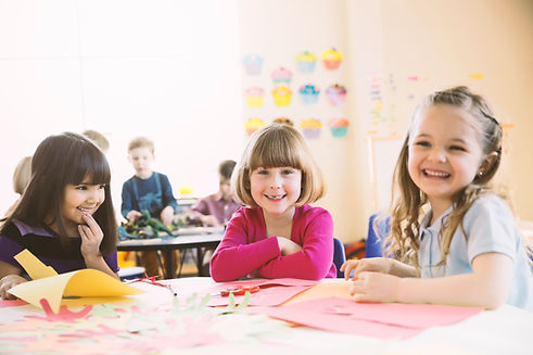 Smiling girls sitting at table in elementary class