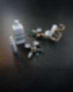 Zubehör-Set für Wasserspender von Aquico, auf dunkler strukturierter Oberfläche. Enthalten sind ein weißer Kanister und eine kleine Flasche mit Aquico-Logo, ein Druckminderer mit zwei Manometern, ein CO₂-Druckregler mit drei Anschlüssen und weitere Mess- und Ventilelemente aus Metall und Kunststoff.