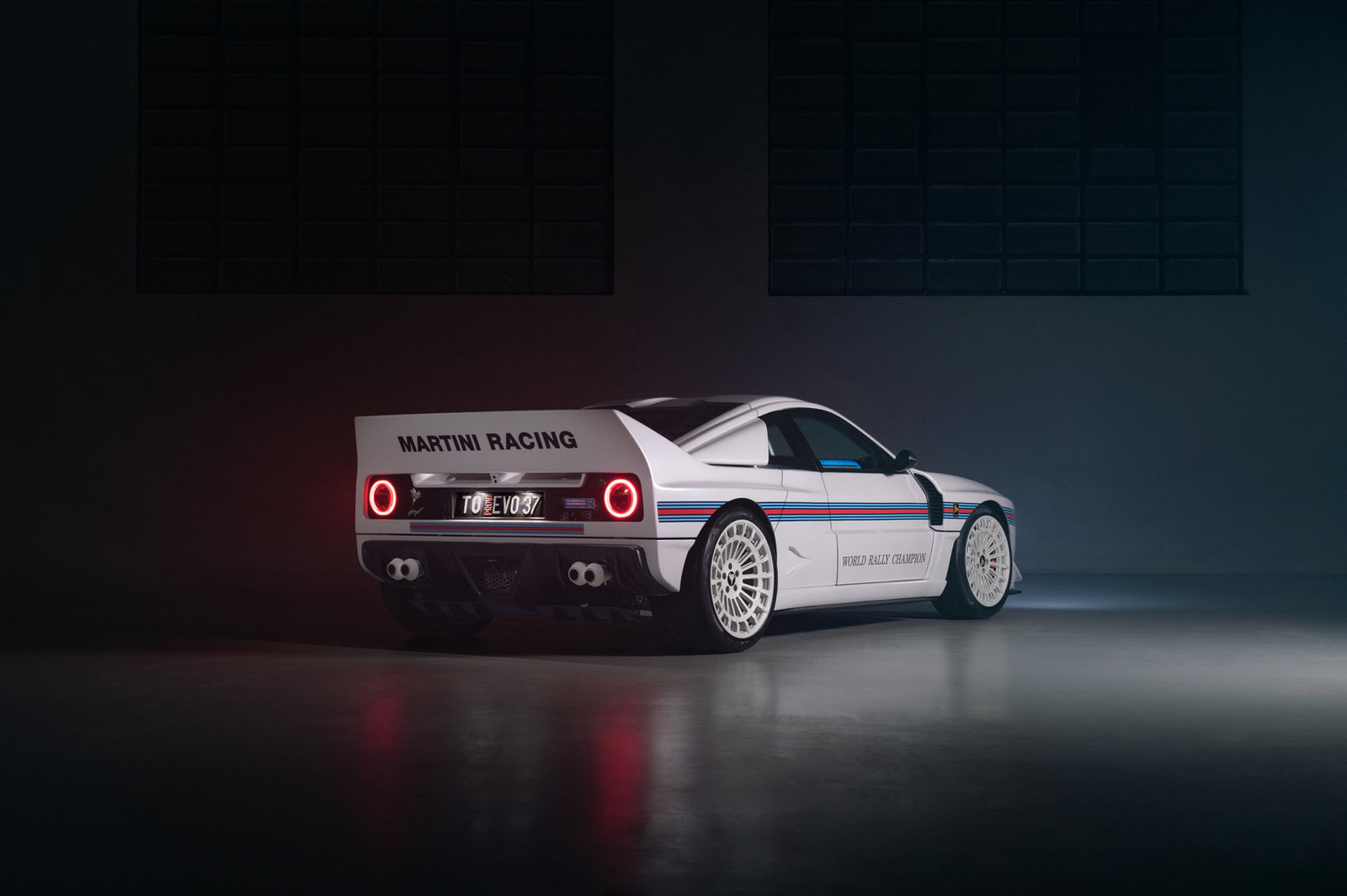 Kimera EVO37 in Martini livery, rear three-quarter view in a dark studio
