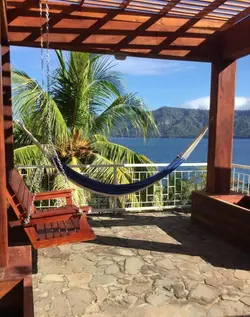 Travelers relaxing and swimming in the warm mineral waters of Laguna de Apoyo volcanic crater lake.