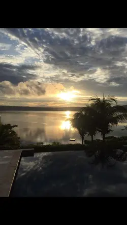 Travelers relaxing and swimming in the warm mineral waters of Laguna de Apoyo volcanic crater lake.