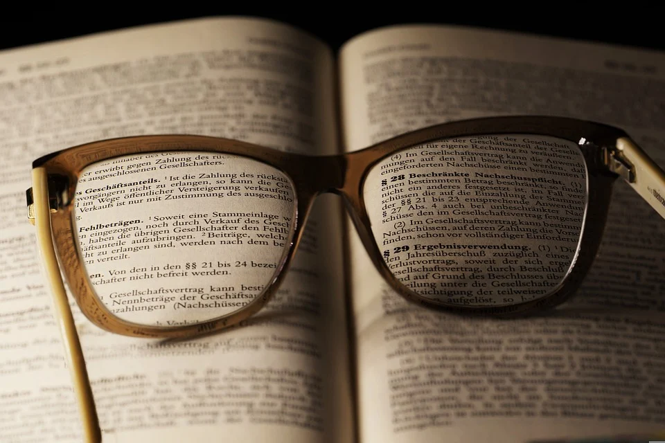 glasses on book with text in lenses in focus , representing clarity