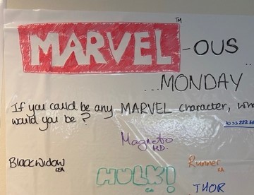 White board containing ice breaker question and answers to what marvel character you would be