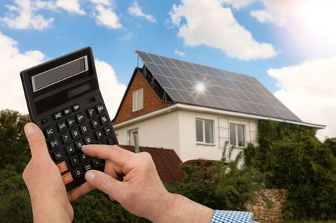 A person calculating energy costs after solar panels were installed.