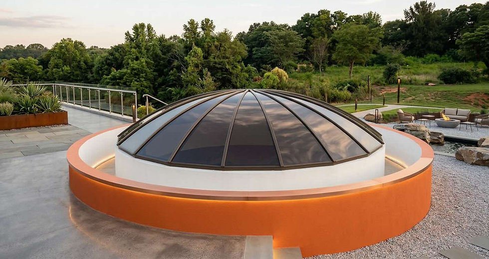Domed skylight installation on a rooftop with an orange curved base surrounded by greenery