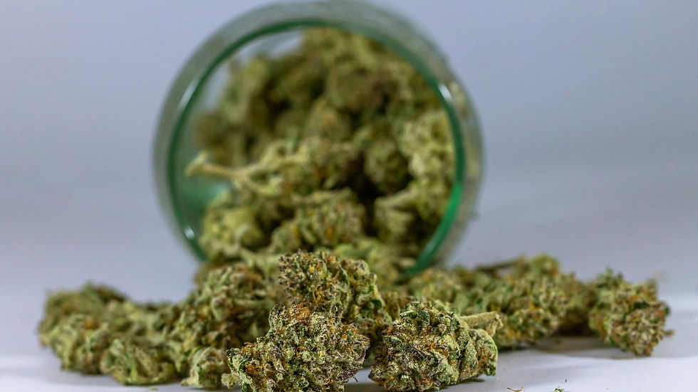 High-quality close-up of cannabis buds spilling from a glass jar.