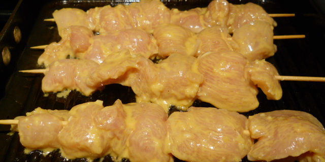 Chicken skewers cooking in a pan