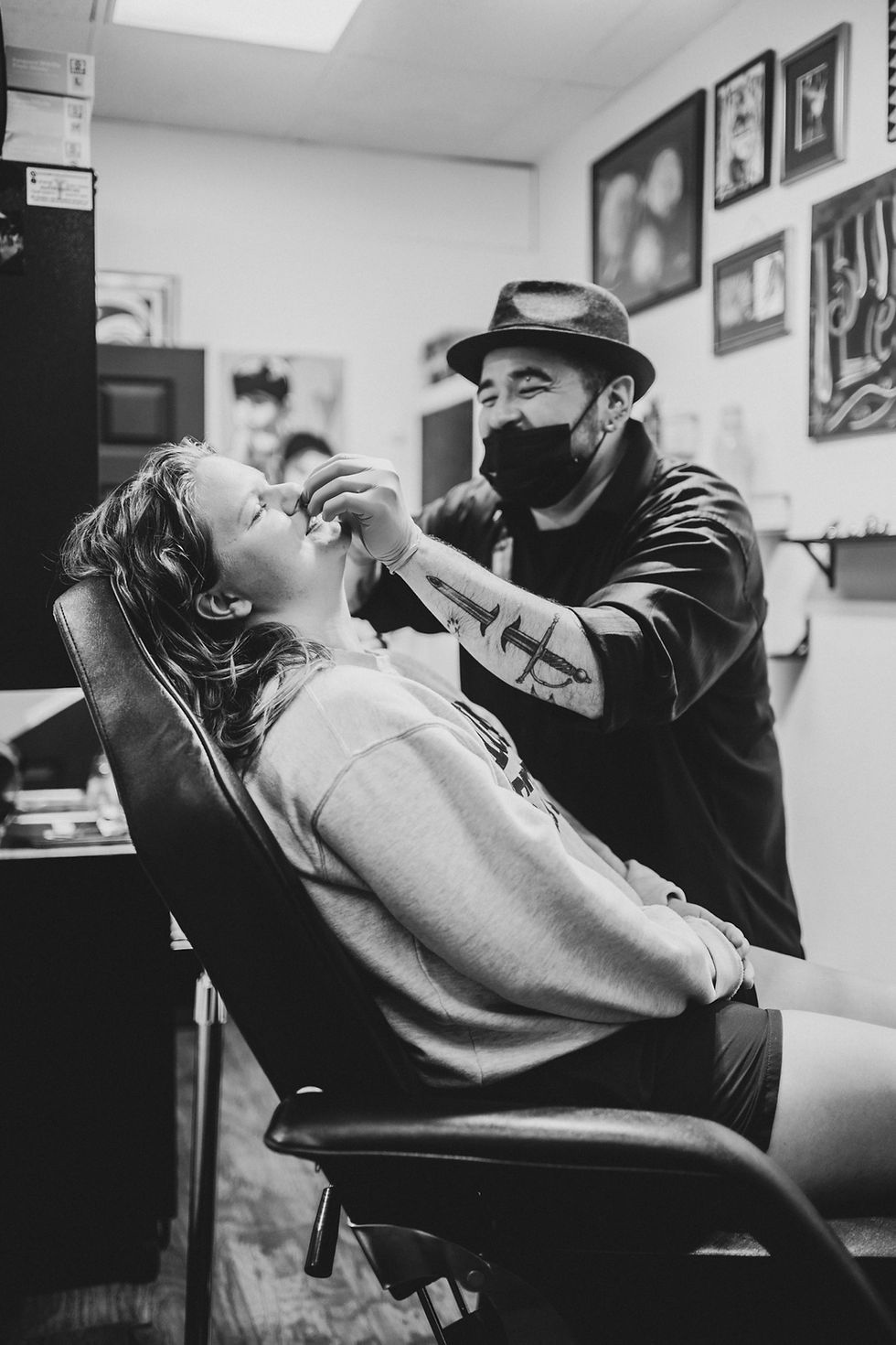 Adam the Piercer smiling while piercing a client