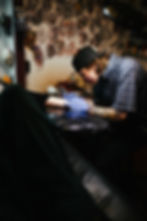 Aiden tattooing a client