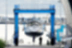 Boat suspended on jib at marina getting cleaned.jpeg
