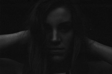 Dark, moody portrait of a person with long hair. Wojciech J Walkowicz