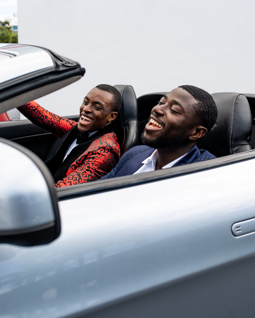 two men are laughing in the back seat of a car