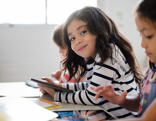 Smiling child reading confidently in French after completing the online course.