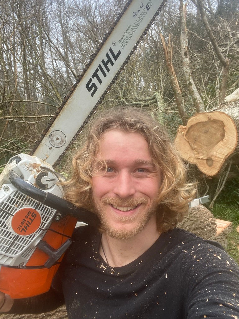 Bespoke furniture maker operating a mobile sawmill with a Stihl MS881 chainsaw, preparing oak planks for future bespoke furniture projects.