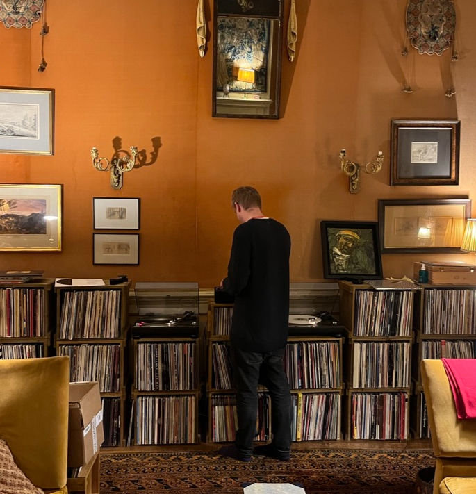 Improvised DJ booth setup with turntables balanced on stacked vinyl record storage crates.