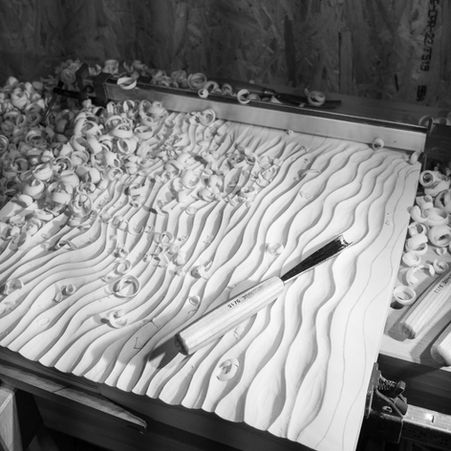 In-progress shot of kelp-inspired design being carved for wooden wall art