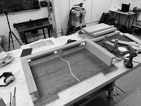 Workshop view of bespoke drinks cabinet assembly in progress, showing craftsmanship and structural detailing.
