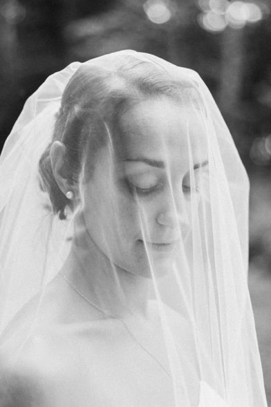 Bride adjusting veil before ceremony at Upstate New York venue.