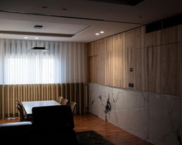 spazio living con boiserie a a tutta altezza marmo e legno