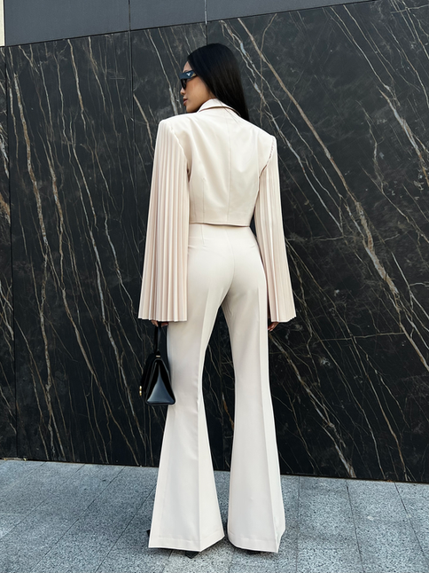 Front view of a model wearing size XXS Eclair Flare Pants in beige, illustrating the perfect fit and flare silhouette.