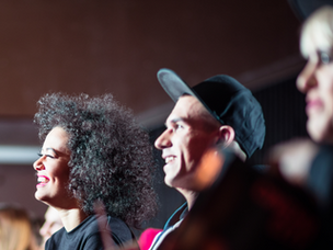 Audience members laughing at a comedian onstage