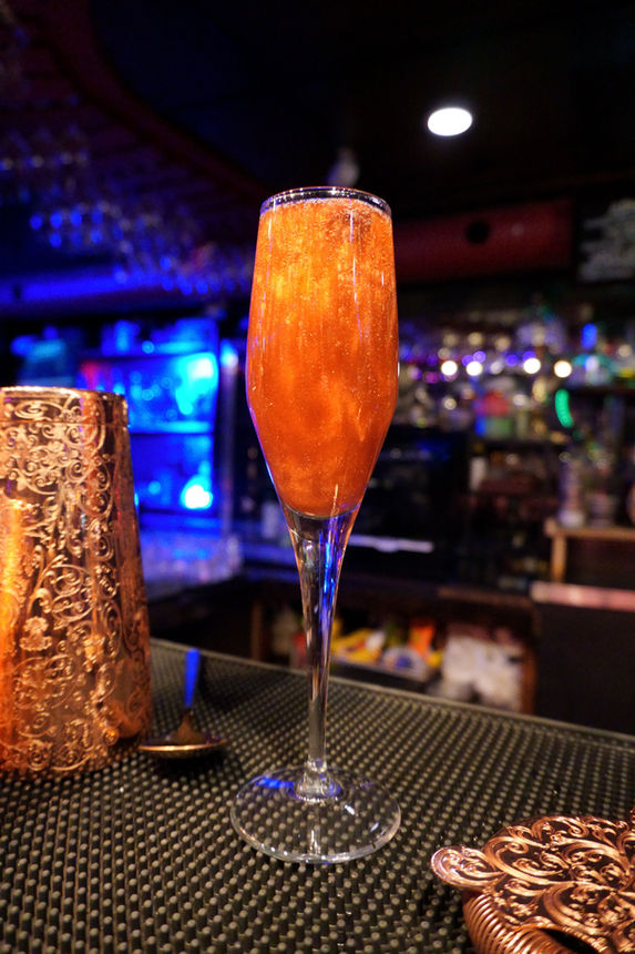 The Wych cocktail - Aphrodite red chambord prosecco champagne flute gold sparkles on bar top