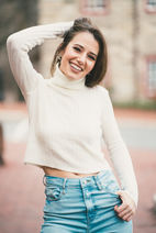 Smiling woman in white turtleneck and jeans