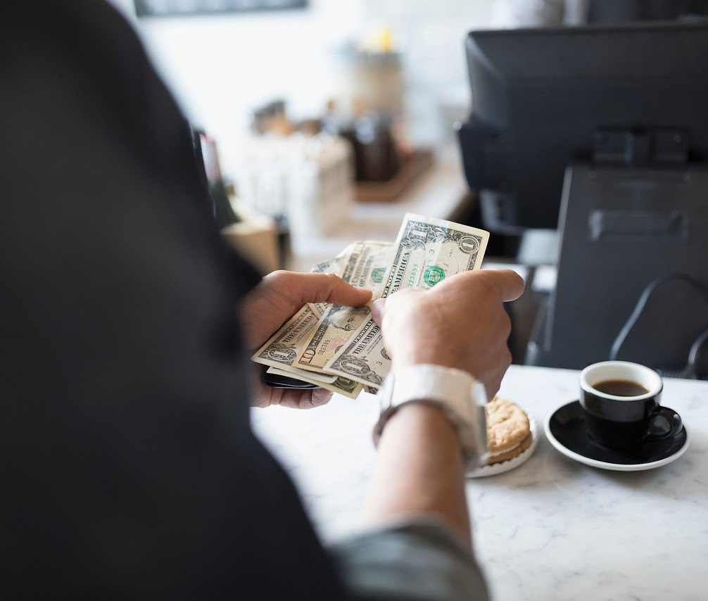 customer-paying-with-cash-at-cafe-counte