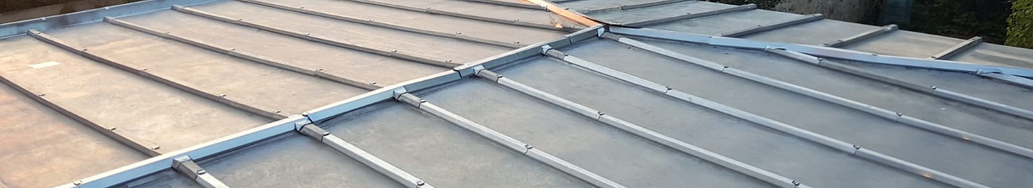 Toiture en zinc avec joint debout réalisée par B.C.M.E., artisan couvreur-zingueur en Haute-Saône