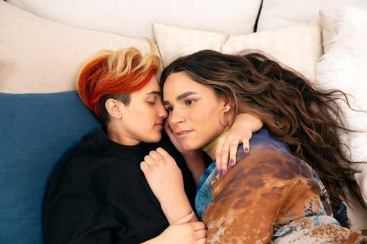 A transmasculine gender-nonconforming person and transfeminine non-binary person waking up