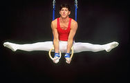 Male gymnast performing rings split