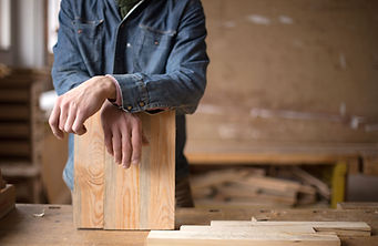 Carpenter Leaning on Piece of Wood