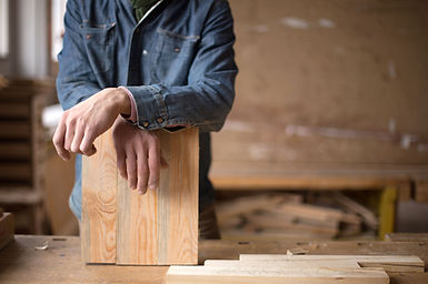 Carpenter Leaning on Piece of Wood