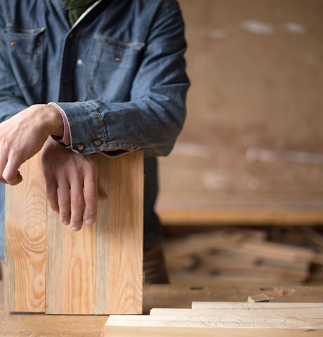 Carpenter Leaning on Piece of Wood