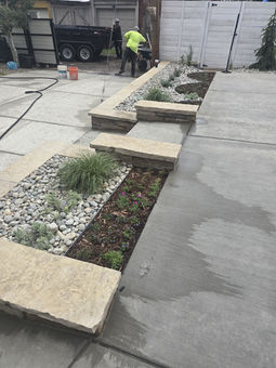 Concrete driveway with modern landscape planter beds.
