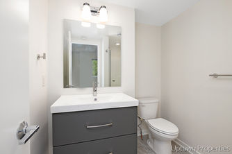Bathroom with a sink, mirror, and toilet; real estate design background.
