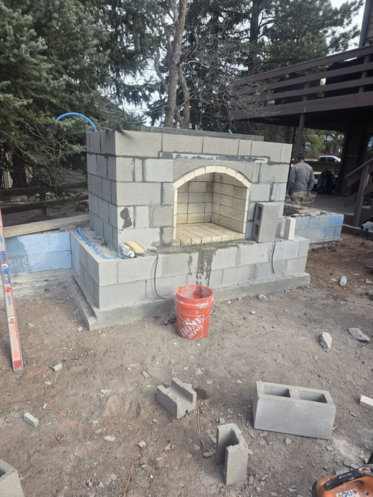 Concrete block fireplace construction in a backyard gallery