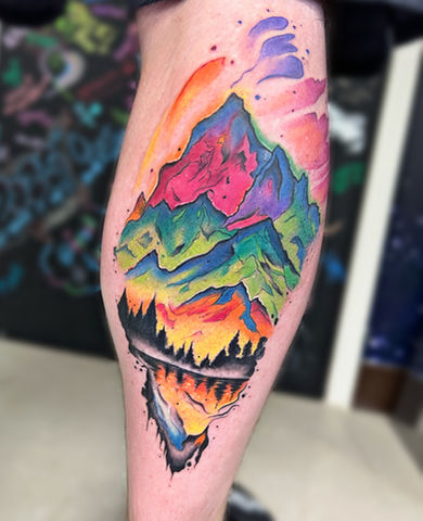 Vibrant watercolor mountain tattoo